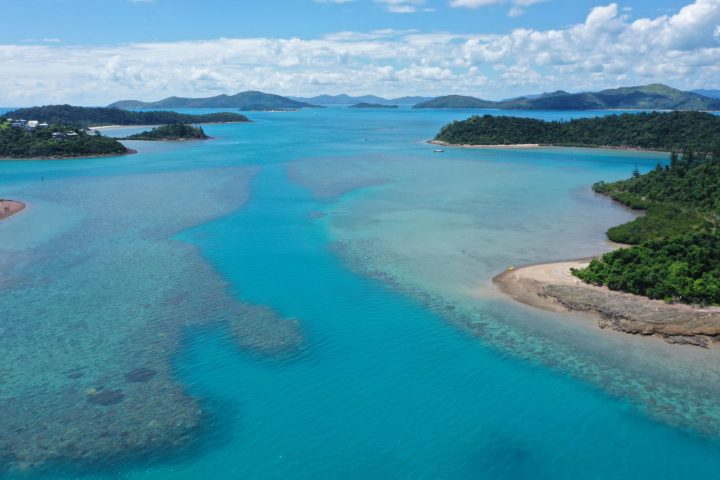 a sandy beach next to a body of water