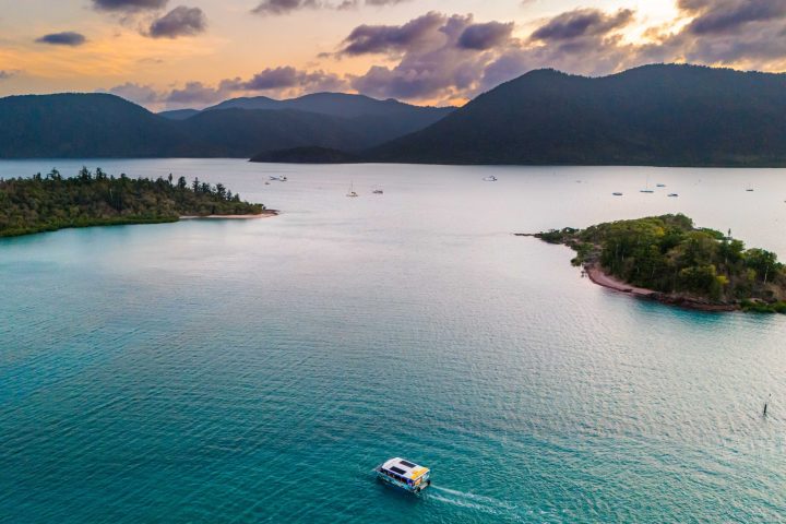 a small boat in a body of water with a mountain in the background