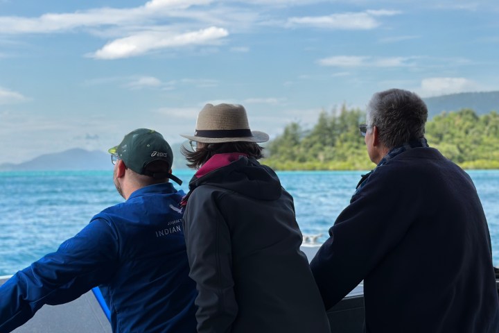 a man standing next to a body of water