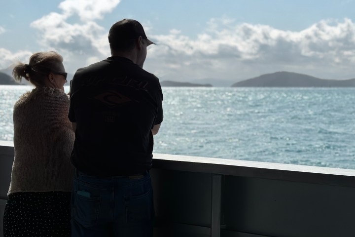 a person standing next to a body of water