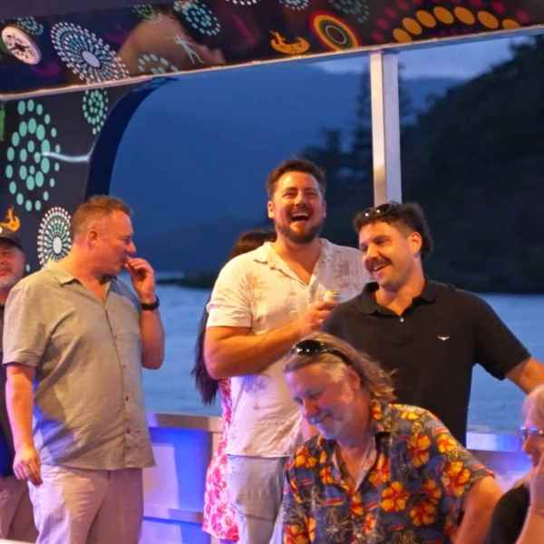 Group of people laughing and talking on a colorful boat.